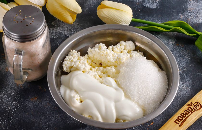 1. Этап. Полезные ватрушки с творогом: В другой емкости соедините оставшийся творог, белок куриного яйца, сахар, соль, сметану любой жирности. Тщательно вымешайте начинку. Желток отложите в сторону, им вы смажете края уже почти испеченных ватрушек.