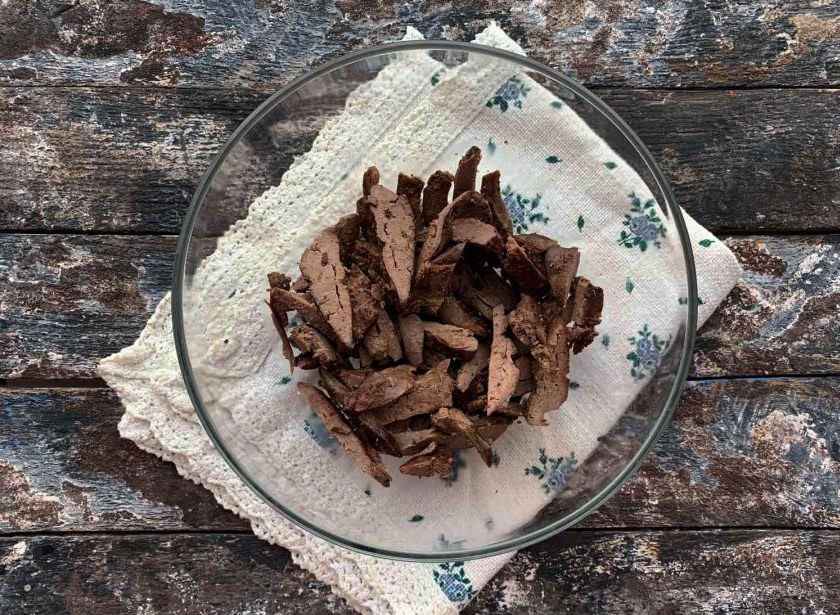 1. Этап. Салат с куриными сердечками и печенью: Печень нарежьте и выложите в глубокую тарелку.