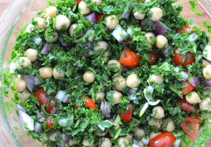 1. Этап. Салат Табуле с нутом: 4. Нарежьте кубиками помидор и лук, выложите к зелени, слейте воду с консервированного нута, по вкусу добавьте соль и перец. Подавайте салат сразу или охладите.