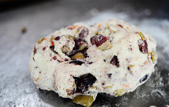 1. Этап. Фокачча с маслинами: 4. Выложить тесто на слегка посыпанной мукой поверхности. Положить нарезанные оливки сверху, затем очень аккуратно вымесить оливки с тестом.