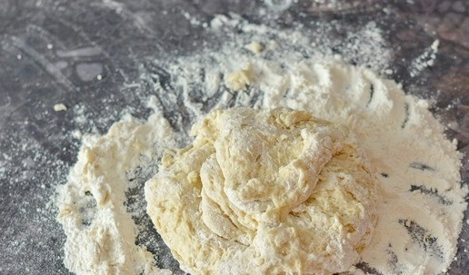 1. Этап. Сдобный калач на сливках: Как только тесто соберётся в единый комок, выложите его на подпыленный мукой стол и вымешивайте до однородности около 10 минут. Количество муки, которое вам понадобится, может отличаться от указанного в ту или иную сторону. Ориентируйтесь не только на указанный вес муки, но и на консистенцию теста. Оно должно быть мягким, не липнуть к рукам, но при этом не плотным.