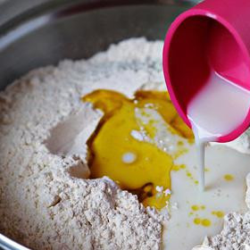 1. Этап. Чесночные булочки: Добавьте оливковое масло, молоко и воду и перемешайте до однородной массы.