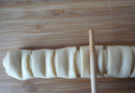 1. Этап. Булочки с плавленым сыром Ассорти: Сверните в рулет оставшуюся часть теста. На разрезанных полосках с помощью деревянной палочки продавите полоски.