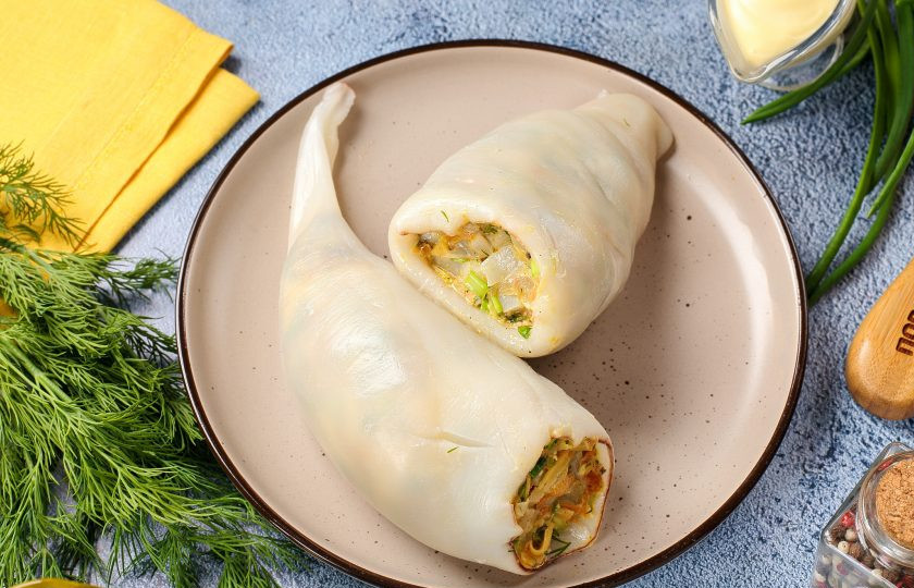 1. Этап. Кальмары фаршированные грибами на сковороде: Получившейся смесью плотно нафаршируйте тушки кальмаров. Если начинки слишком много, срезы можно скрепить деревянными зубочистками, чтобы начинка не вывалилась в процессе жарки.