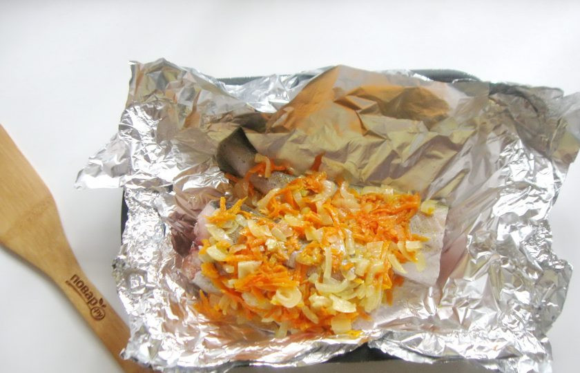 1. Этап. Диетический минтай в фольге в духовке: На минтай выложите лук с морковью, которые тушились в сковороде. Заверните плотно в фольгу рыбу с овощами.