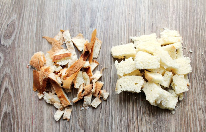 1. Этап. Торт без выпечки из батона: Батон порежьте на куски и удалите корочки. Очищенную булку порежьте на более мелкие кусочки.