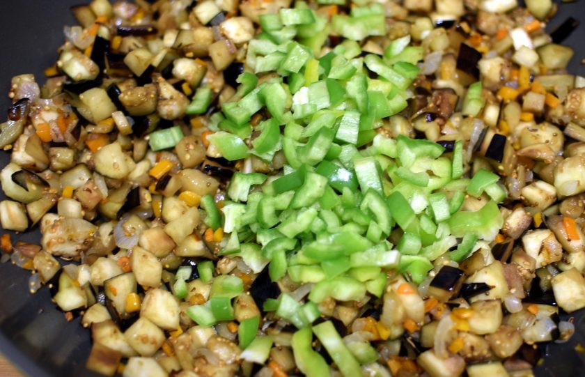 1. Этап. Пряная баклажанная икра: Добавьте сладкий и острый перец. Жарьте еще минуты 2-3.