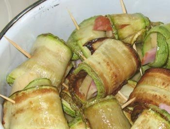 1. Этап. Кабачки с ветчиной: Полоску кабачка солим, перчим и намазываем измельченным чесноком. Выкладываем на кабачок ломтик ветчины и сыра, заворачиваем в рулетик. Скрепляем края зубочисткой. Укладываем в жаропрочную посуду и запекаем в нагретой до 180 градусов духовке минут 10.