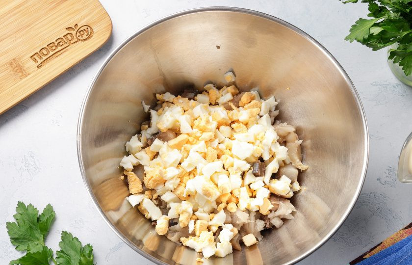 1. Этап. Салат со скумбрией и соленым огурцом: Добавьте нарезанные кубиками яйца.