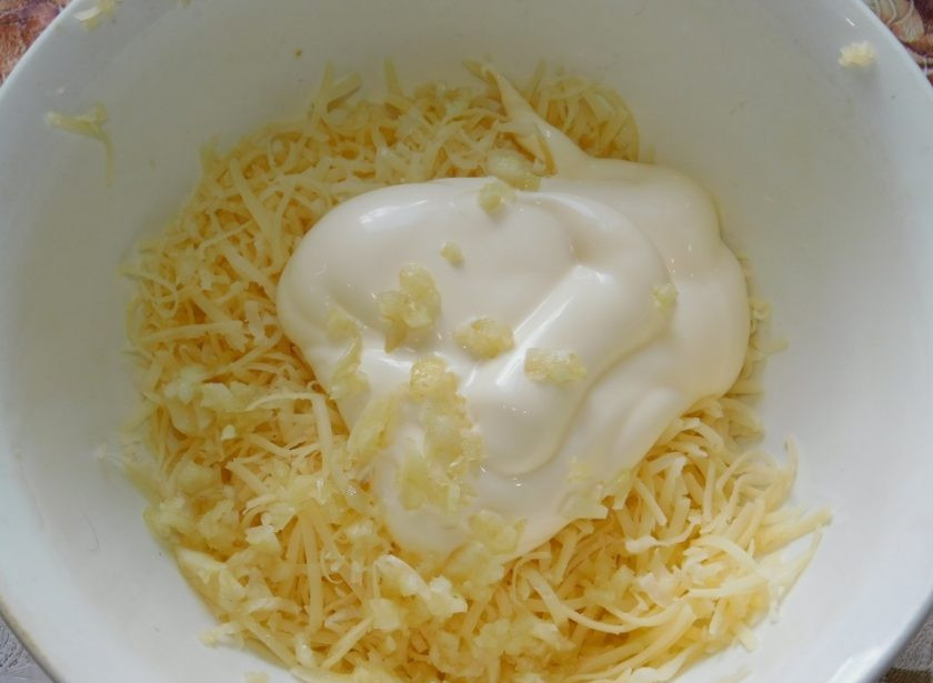 1. Этап. Чесночные бутерброды с яйцами и помидорами: Сыр натрите на мелкой терке. Чеснок пропустите через пресс. Добавьте майонез. Все хорошо перемешайте.