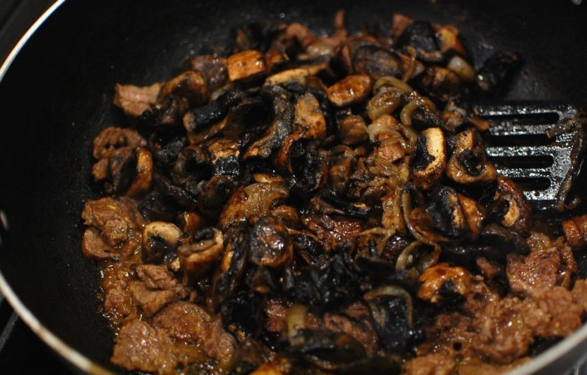 1. Этап. Вкусный бефстроганов: 6. Верните грибы в сковороду к мясу, влейте бульон, доведите до кипения.