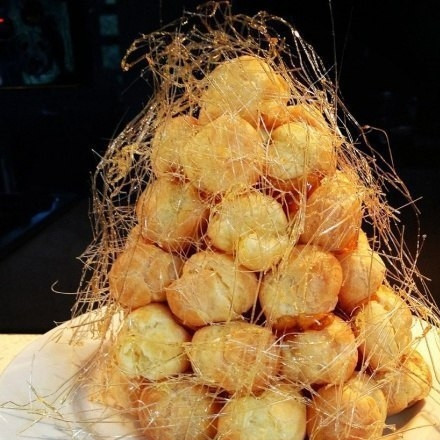 1. Этап. Торт Крокембуш: 9. Шарики с кремом укладываем вокруг конуса этажами, обмазывая с помощью кондитерской кисточки получившейся карамелью. Готовую елочку можно украсить цветными конфетками и ягодками, но она и сама по себе аппетитная.