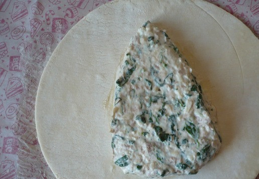 1. Этап. Рождественская елка из слоеного теста: Вбейте яйцо, по вкусу добавьте черный молотый перец (если есть необходимость в соли, то можете посолить по вкусу), все перемешайте. Начинка для пирога готова. Возьмите круглый пласт слоеного бездрожжевого теста и выложите приготовленную начинку в центр, разложите ее в форме треугольника.