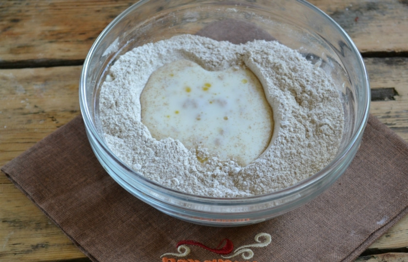 1. Этап. Ржаные лепёшки без дрожжей: В миске с мукой сделайте небольшую воронку и залейте туда кефир.