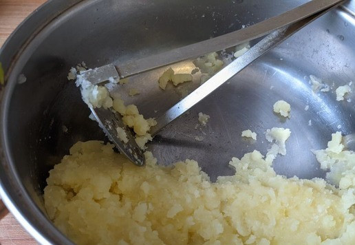 1. Этап. Запеканка из тунца А-ля Брандада: Сливаем воду, разминаем картофель толкушкой.