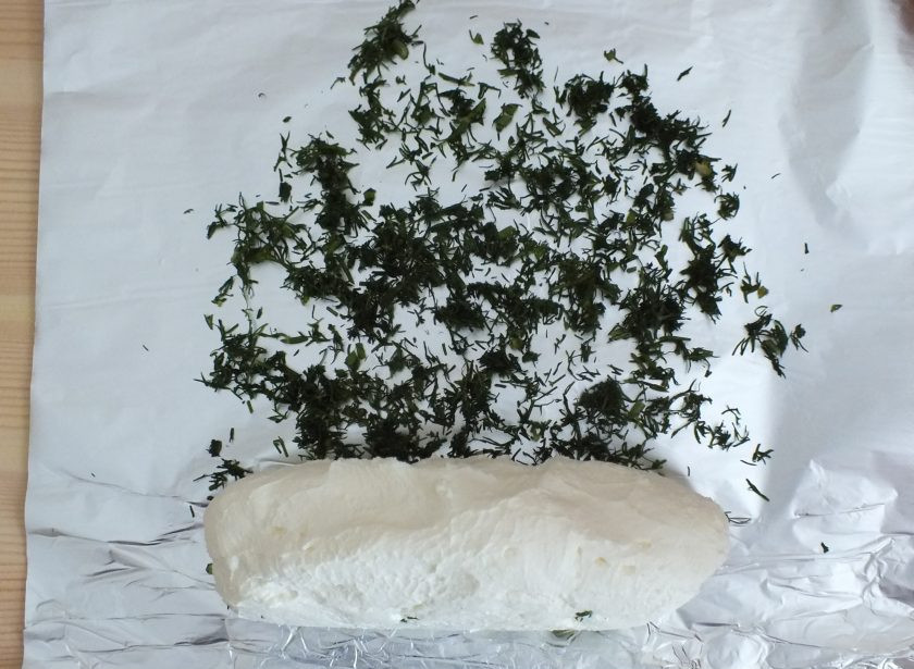 1. Этап. Сыр из кефира и сметаны: Нарежьте мелко зелень и разложите ее на фольге. Из полученной сырной массы скатайте валик, переложите на фольгу и прокатайте по зелени.