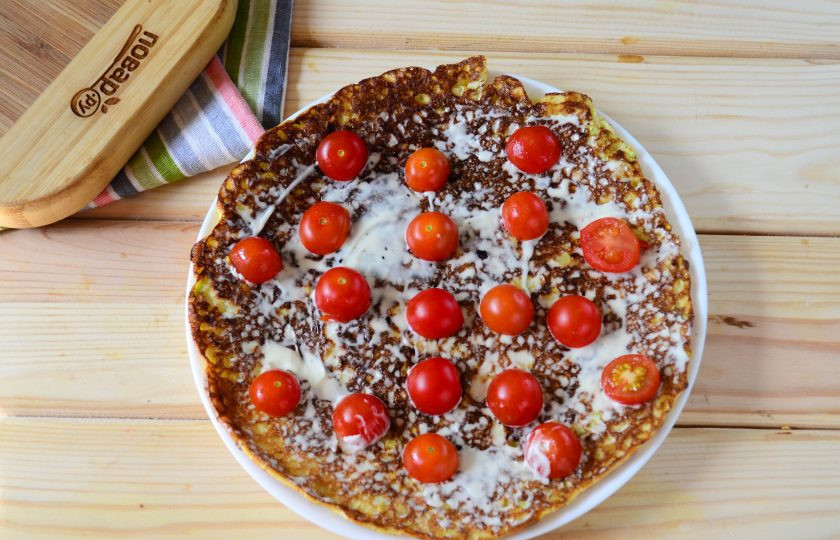 1. Этап. Кабачковый торт (мастер-класс): Когда кабачковые блины полностью остынут, начинайте собирать торт. На плоскую тарелку, подходящую по диаметру, положите первый блин. Смажьте его майонезом и выложите дольки помидоров. В этот раз я использовала помидоры черри: просто разрезала их пополам и выкладывала негусто на блин.