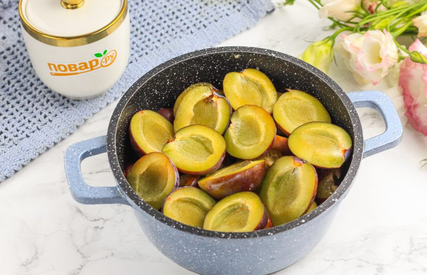 1. Этап. Варенье из недозрелых слив: Разрежьте фрукты пополам и удалите косточки. Выложите половинки слив в казан или кастрюлю с антипригарным дном.