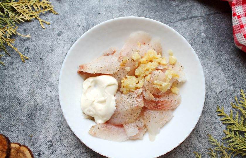 1. Этап. Пирог с муксуном: Кусочки филе выложите в тарелку, добавьте обжаренный лук, майонез. Все посолите, поперчите и перемешайте.