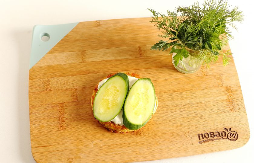 1. Этап. Драник-бургер: Смажьте драник соусом и сверху выложите нарезанный кружочками огурец.