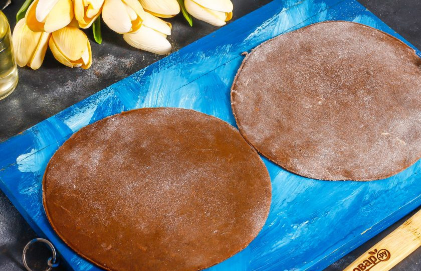 1. Этап. Шоколадный медовик: Извлеките тесто из холодильника и разделите на части. Каждую из них раскатайте и обрежьте, используя тарелку.