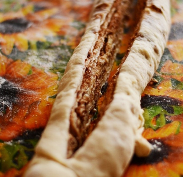 1. Этап. Крендель с корицей: Сделайте разрез в длину по центру насквозь, оставьте с одной стороны расстояние в 5 см. нетронутым.