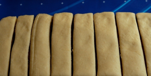 1. Этап. Пирожки с черникой: Вдоль короткой стороны разрешьте тесто на полоски шириной 2 - 3 см.