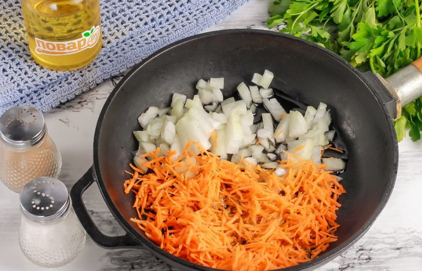 1. Этап. Борщ из печеной свеклы с вином: Нарежьте лук мелкими кубиками, а морковь натрите на терке с мелкими ячейками. Прогрейте на сковороде растительное масло и отпассеруйте в нем овощные нарезки примерно 3-5 минут до румяности.