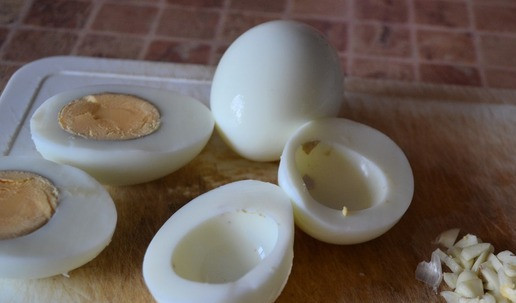 1. Этап. Закуска Парусники из яиц: Яйца отварить. Разрезать аккуратно пополам. Вытащить желток. Мелко нарезать чеснок.