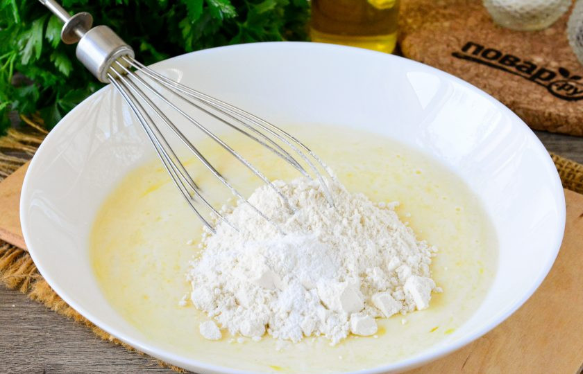 1. Этап. Оладьи с сосисками на кефире: Всыпьте просеянную пшеничную муку с разрыхлителем и размешайте тесто, чтобы не было комочков.
