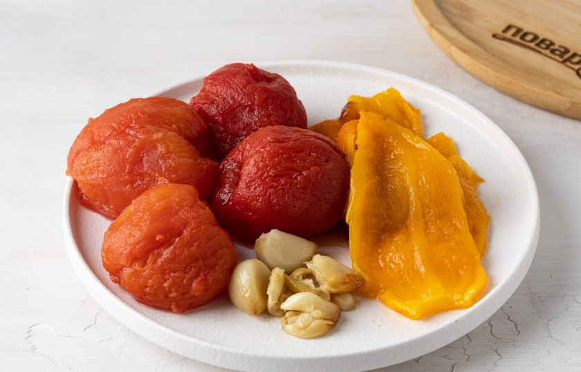 1. Этап. Томатный суп с кокосовым молоком: Зубчики чеснока выдавите из кожуры. Перец и помидоры переложите в пакет, пропарьте около 5-10 минут. Очистите от шкурки и семян перец и помидоры.