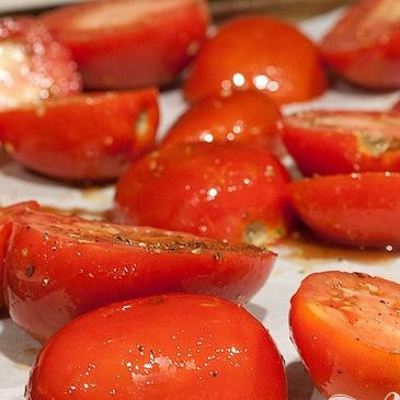 1. Этап. Суп с запеченным чесноком, помидорами и сыром: 3. Разрезать помидоры пополам и положить в большую миску. Добавить 2 столовые ложки оливкового масла, бальзамический уксус, сахар, соль, перец, красный перец хлопьями и итальянскую приправу. Перемешать. Выложить помидоры на второй противень и запекать в предварительно нагретой духовке 45 минут.
