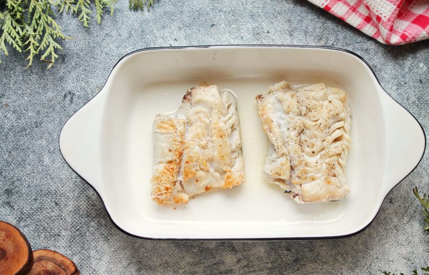 1. Этап. Треска по-поморски: В сковороду налейте растительное масло и разогрейте на среднем огне. Обжарьте треску с двух сторон до румяной корочки по три минуты с каждой стороны. Переложите обжаренную треску в смазанную форму для запекания.