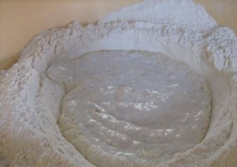 1. Этап. Осетинский пирог с картошкой: Начнём с приготовления теста. Подогрейте молоко и полностью растворите в нём дрожжи, сахар и соль. Добавьте просеянную муку.