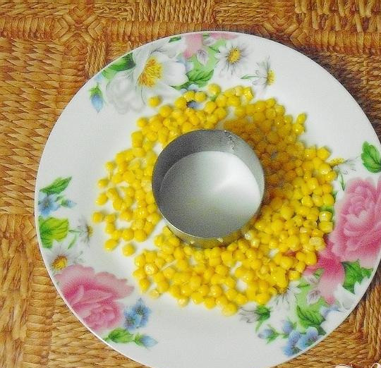 1. Этап. Салат Золотое кольцо: 4. В середине блюда установим кольцо. Треть банки кукурузы выложим вокруг него. Половину тертого картофеля выкладываем на кукурузу, утрамбуем, посолим и смазываем сметаной. Тушеные грибы выкладываем на картошку, утрамбовываем.