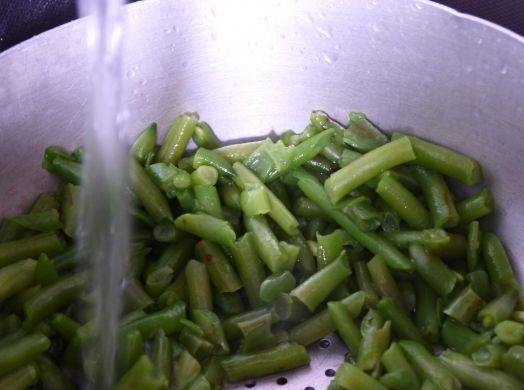 1. Этап. Салат из фасоли стручковой: Дайте стечь воде с фасоли через дуршлаг. Охладите фасоль водой.