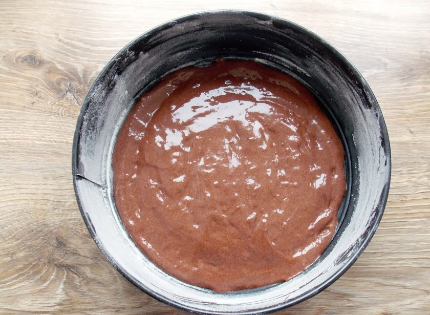 1. Этап. Торт Шоколадное птичье молоко: Форму для выпечки смажьте растительным маслом и обсыпьте мукой. Вылейте в форму тесто и разровняйте.