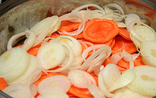 1. Этап. Минтай в томатном соусе: 3. Луковицы очистить и нарезать кольцами. На сковороду налить немного растительного масла. Отправить туда морковь и лук, обжарить, пока овощи не станут мягкими.