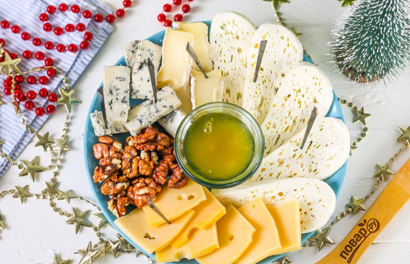 1. Этап. Сырная тарелка на Новый год: Воткните в ломтики сыров шпажки, чтобы гостям было удобнее их брать и подайте сырную тарелку к столу в новогоднюю ночь.