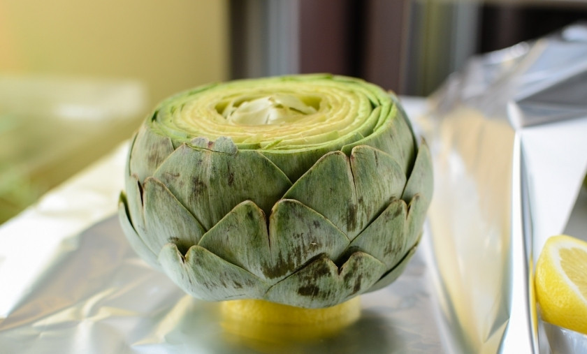 1. Этап. Артишоки в духовке: Приготовьте листы фольги для запекания. Положите на середину листа кусочек лимона. И на него основанием 