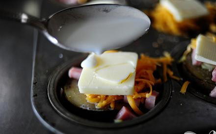 1. Этап. Картофель с сыром и зеленым луком: 4. Положить сверху каждого отделения ломтик сливочного масла и полить 1 чайной ложкой молока пополам со сливками.