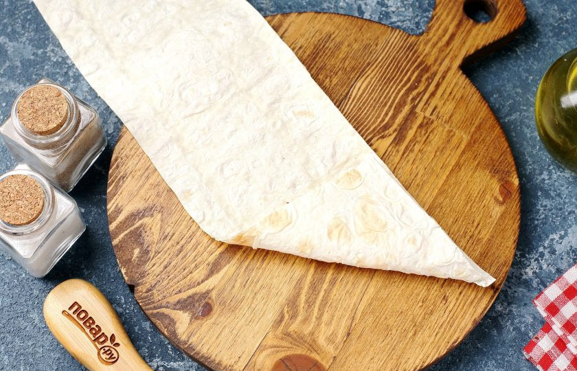 1. Этап. Конвертики из лаваша с варёными яйцами и сметаной: Сложите край лаваша как на фото, чтобы начинка была закрыта. Должен получиться своеобразный треугольник.