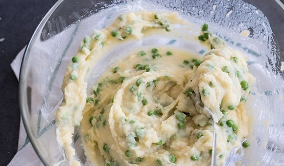 1. Этап. Картофельный пирог с зеленым горошком: 4. Отдельно в миске взбейте яйцо, влейте молоко, добавьте копченый сыр, нарезанный кубиками. Добавьте эту смесь к картофелю с горошком, все перемешайте.