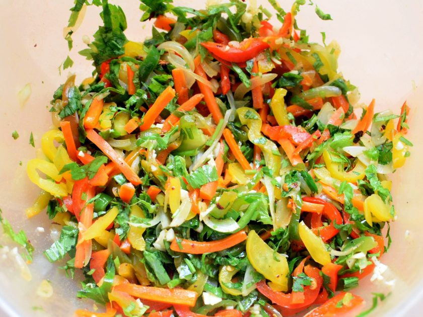 1. Этап. Острые пикантные цукини с овощами: Выложите горячие овощи в миску к зелени и перемешайте.