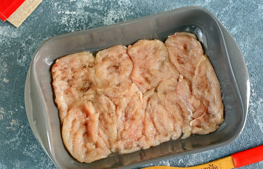 1. Этап. Запеканка из куриной грудки: Куриное филе нарежьте порционными кусочками, отбейте и сложите в один слой в смазанную маслом жаропрочную форму. Посолите и поперчите по вкусу.