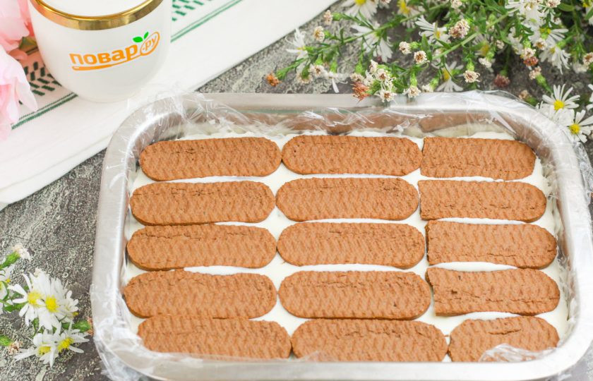 1. Этап. Торт из печенья с кремом из сметаны и сгущёнки: Выложите часть крема и распределите по печенью, стараясь добавить не слишком много крема. Затем снова выложите слой печенья и т.д., пока не закончатся продукты. Отправьте форму в холодильник минимум на 4-6 часов для пропитывания.