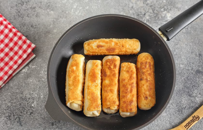 1. Этап. Рулетики из теста с картошкой: Обжарьте рулетики в сковороде на сильном огне с двух сторон. Необязательно доводить тесто до готовности, достаточно лишь, чтобы оно слегка подрумянилось.