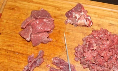 1. Этап. Бифштекс из фарша в духовке: Речь наша пойдет сегодня о приготовлении большого, вкусного и сочного бифштекса! Для его приготовления понадобится говяжья вырезка. Я использовала обычную охлажденную мякоть говядины. Из нее получается тоже очень вкусно, но, разумеется, не настолько нежно, как если готовить из вырезки. И в том, и в другом случае, мясо нужно промыть и просушить. Обрежьте все пленки и жилки, нарезать вначале тонкими полосками. Потом полоски нарезаются небольшими кубиками, как показано на фото.