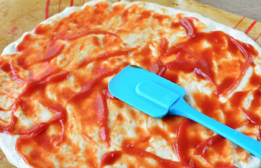 1. Этап. Пицца с бананами: Тесто раскатайте тонко, смажьте кетчупом.