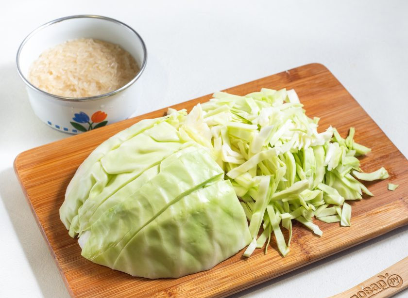 1. Этап. Рис с мясом и капустой в сковороде: Пока жарится мясо, промойте рис и нашинкуйте не очень крупно капусту.
